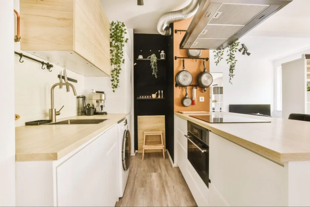 Interior of modern kitchen with white furniture and in-cupboard waste bin, promoting hidden trash storage and improved hygiene.
