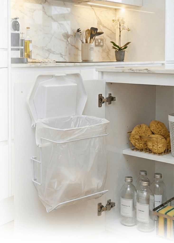 Patented Rack Sack hanging waste management system installed as an under sink garbage bin, featuring a white refill bag held by Rack Sack’s metal frame inside a kitchen cabinet door.