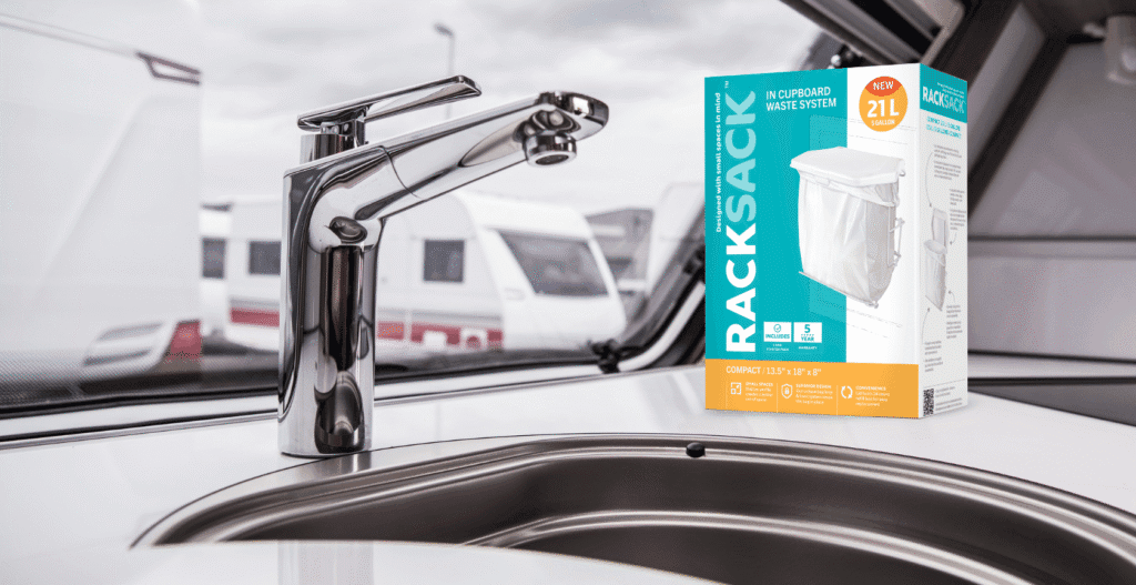 Rack Sack In-Cupboard Waste System, a space-saving trash can designed for small spaces, sitting on a modern RV kitchen counter next to a chrome sink faucet.