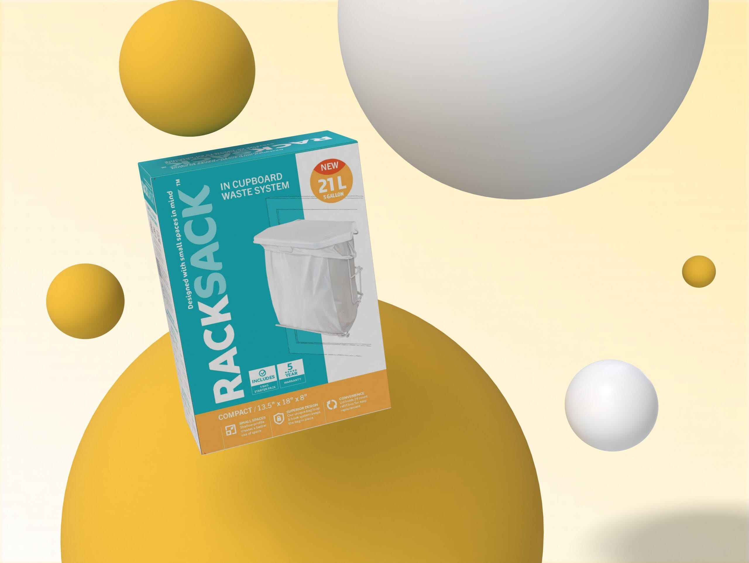 Emballage du système de poubelle suspendue «&nbsp;Rack Sack In Cupboard Waste System&nbsp;», présenté en perspective sur un fond minimaliste. La boîte, de couleur turquoise, blanche et orange, arbore l'inscription «&nbsp;RACKSACK&nbsp;» à la verticale et les détails du modèle «&nbsp;Compact 21&nbsp;L / 5&nbsp;gallons&nbsp;». Sur le devant figure une image de la poubelle suspendue blanche. Des sphères géométriques 3D, dans des tons de jaune et de blanc, entourent la boîte, comme suspendues sur un fond crème clair.